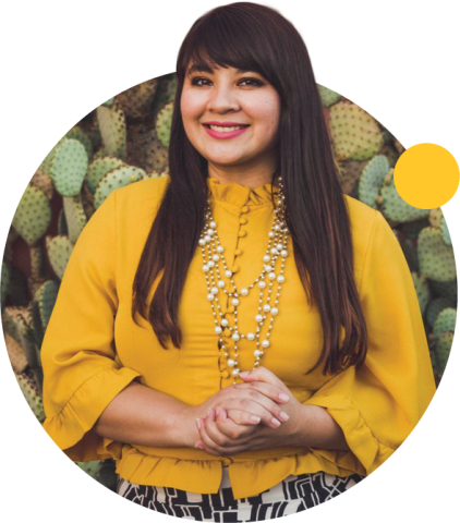 Smiling Reyna Montoya with prickly pair cacti behind her.